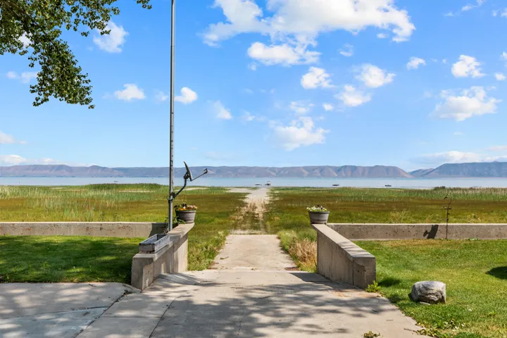 Expansive waterfront access with a concrete pathway and surrounding grassy areas