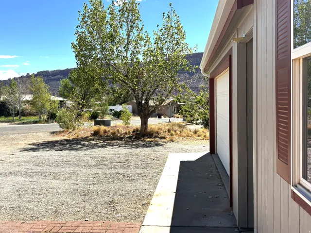 Property exterior featuring vertical siding, brown window shutters, and a prominent garage door