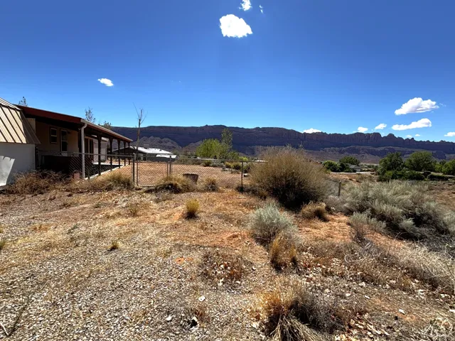 Property featuring a covered porch, chain-link fencing, and a metal roof