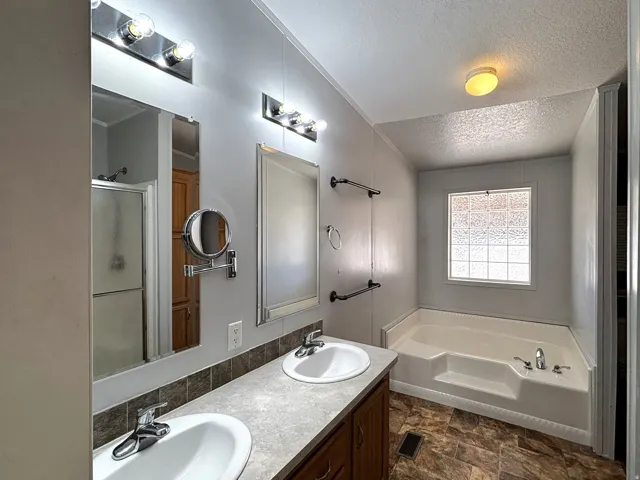 Ensuite bathroom. Double vanity with integrated sinks, full-width mirror, and a built-in shower