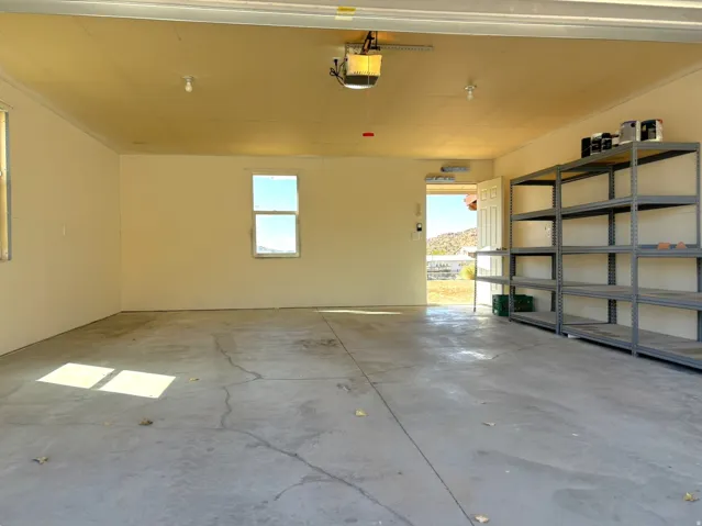 Concrete flooring garage with multiple windows and built-in shelving
