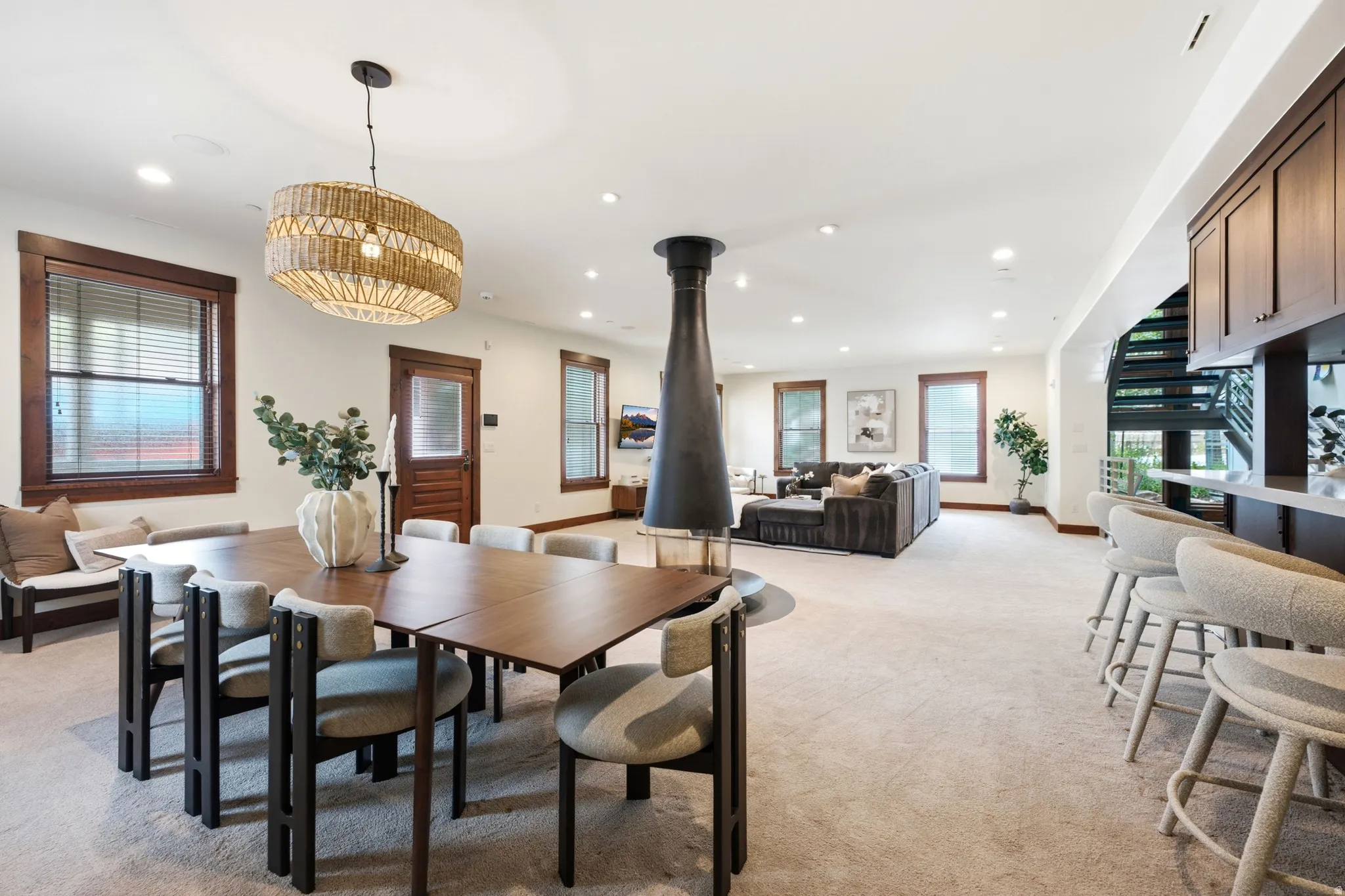 Open-concept living space with recessed lighting, wood-trim windows, and a built-in bar