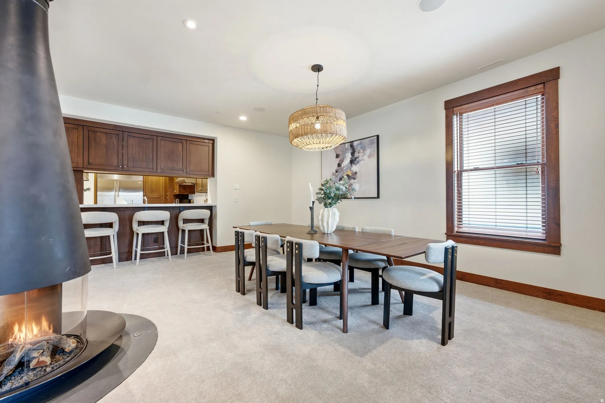 Freestanding fireplace with a glass enclosure, wood-finish cabinetry, and a built-in bar