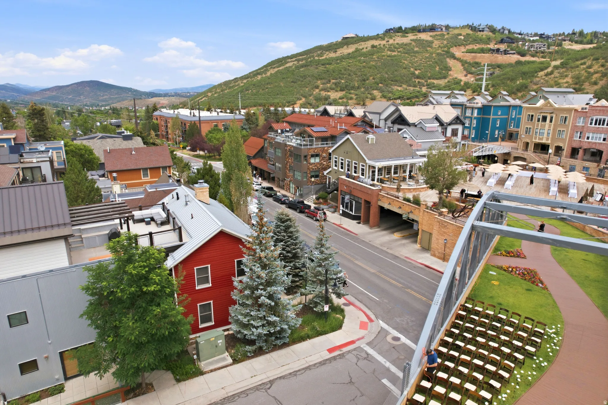Elevated perspective showcasing a mixed-use neighborhood with architectural diversity, a prominent street, and a pedestrian bridge