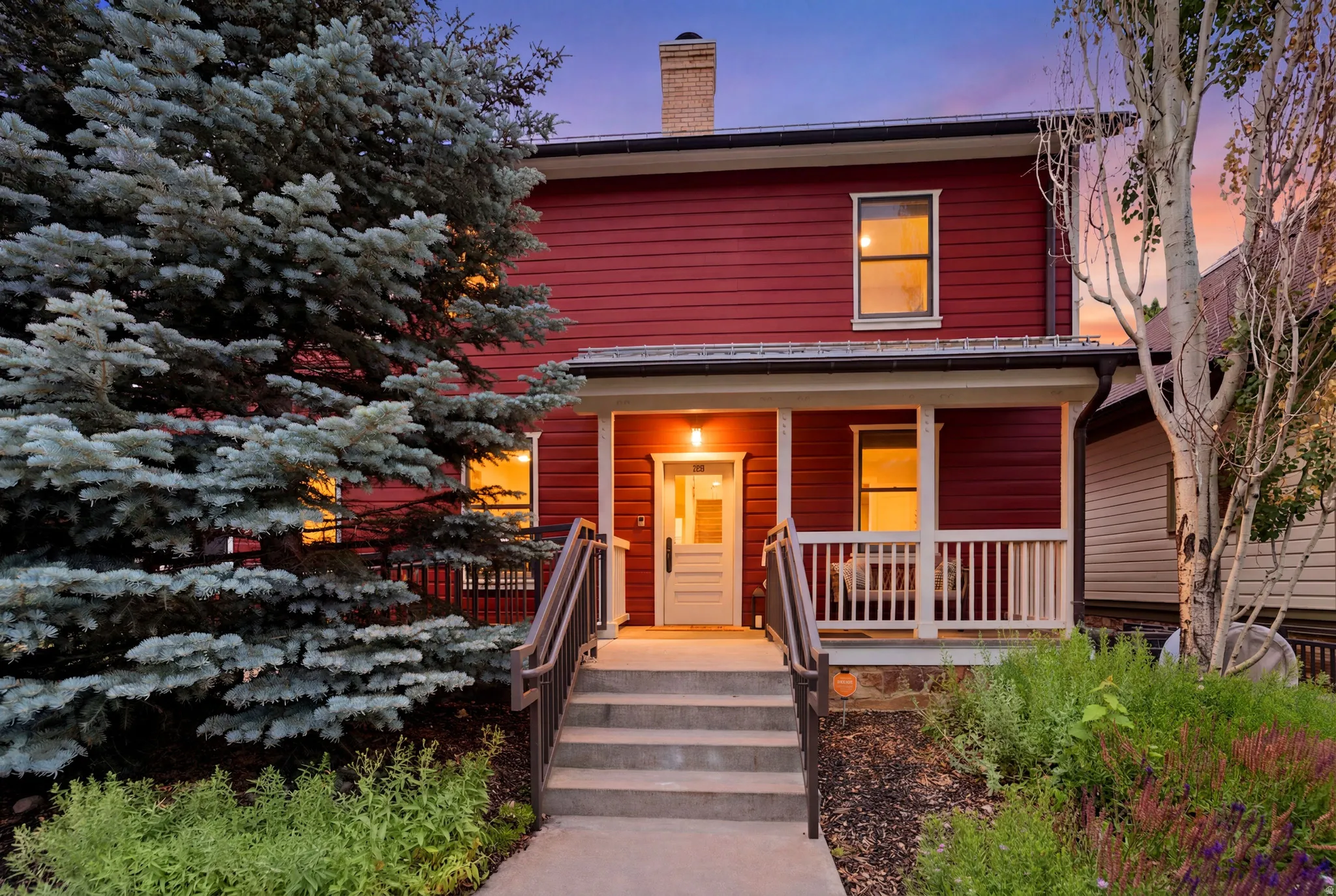 Red siding exterior with a covered front porch featuring white railings