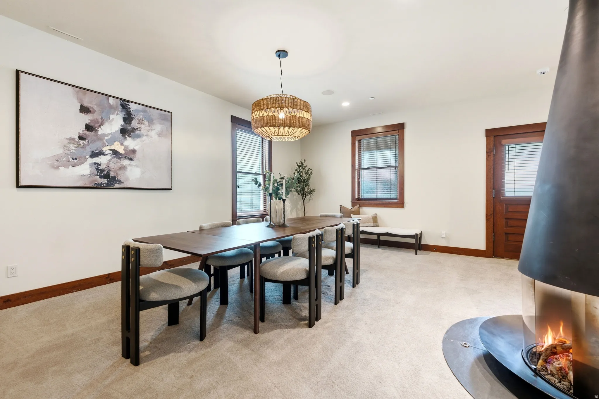 Freestanding fireplace feature, recessed lighting, and a woven pendant light fixture