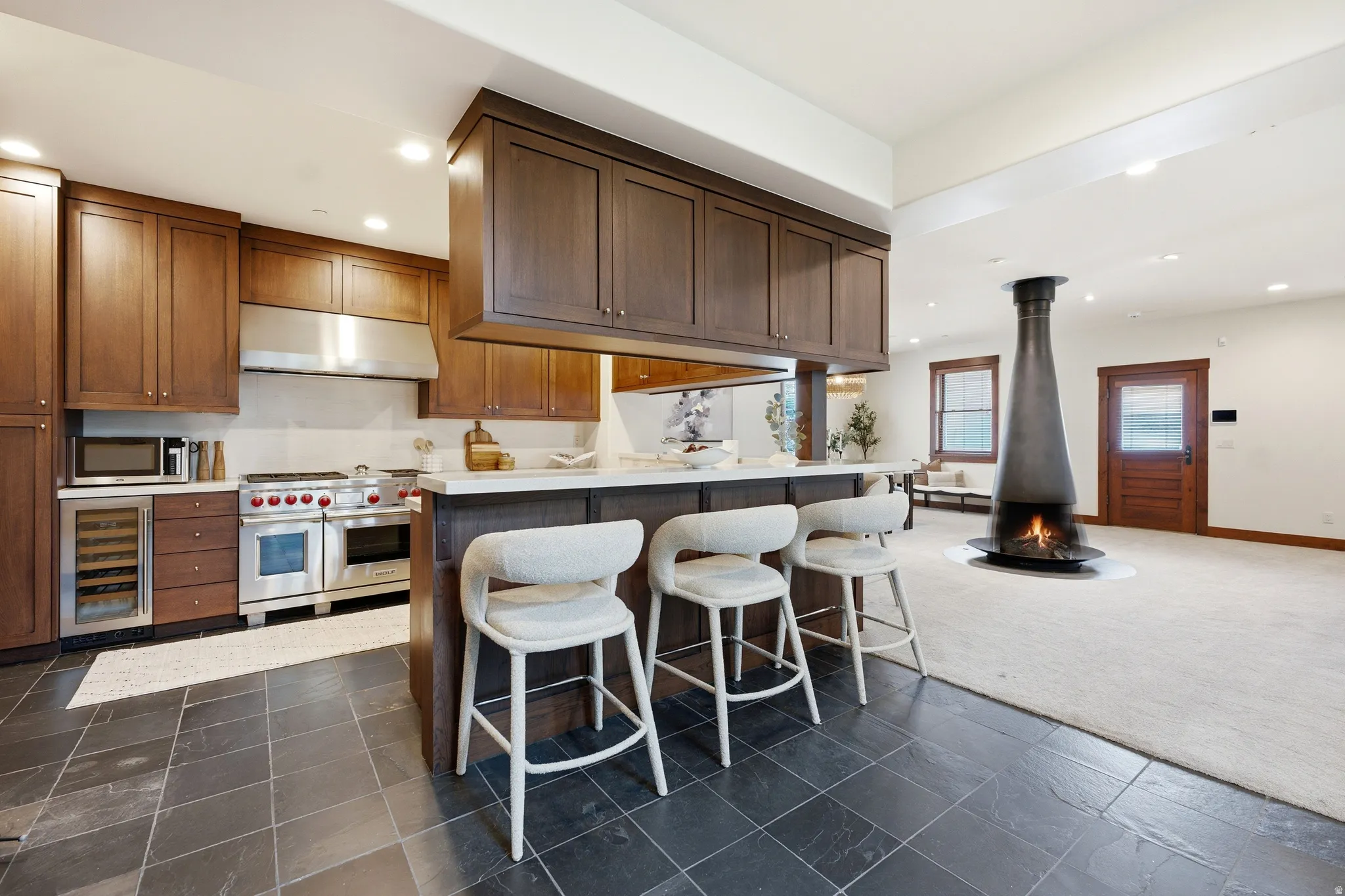Gourmet kitchen with stainless steel appliances, dark wood cabinetry, and a white countertop island