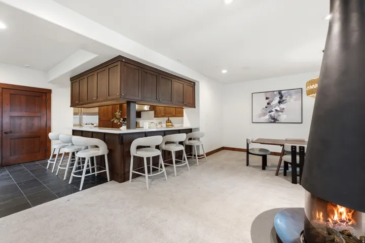 Built-in wet bar with dark wood cabinetry and a light-toned countertop