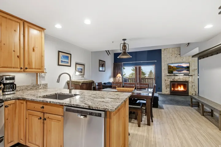 Kitchen featuring wood cabinetry, granite countertops, and a stainless steel dishwasher
