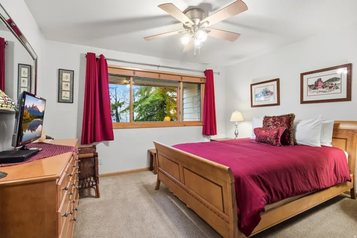 Wall-to-wall carpeting and a ceiling fan with integrated lighting