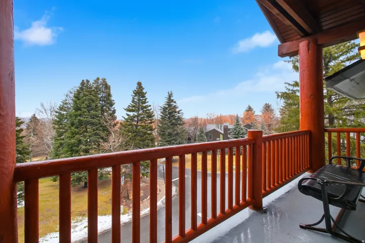 Balcony featuring a wood plank ceiling and wood-finish railings