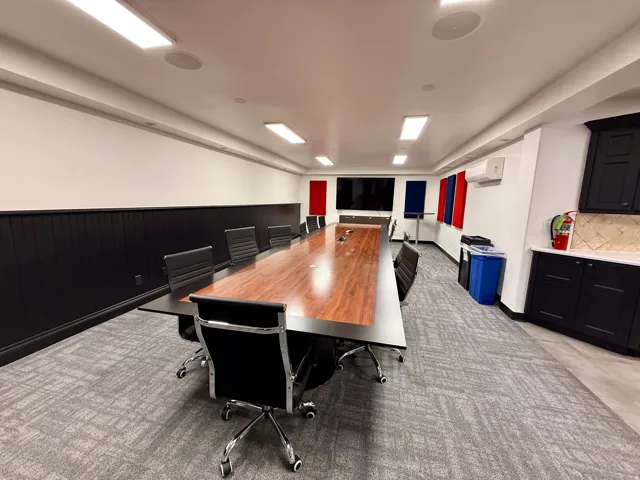 Recessed ceiling lighting, a built-in wall-mounted display, and dark paneled wainscoting