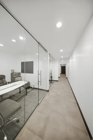 Recessed ceiling lighting, full-height glass partitions, and large format floor tiling