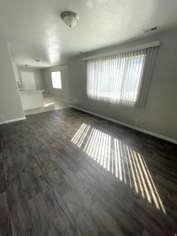 Wood-finish flooring, vertical window blinds, and recessed lighting fixtures