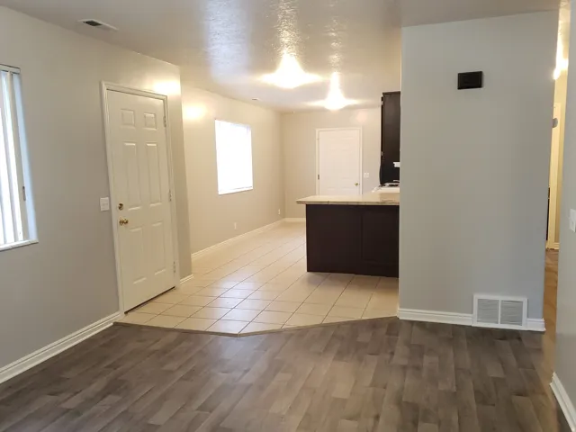 Wood-finish flooring, tiled flooring, built-in breakfast bar, white interior doors, and multiple windows