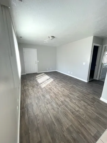 Expansive interior space featuring wood-finish flooring, light gray wall tones, and recessed lighting