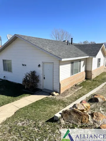 White vinyl siding exterior with brick-finish foundation