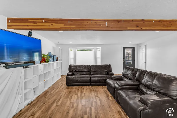 Wood-finish flooring throughout, complemented by a prominent wood beam detail