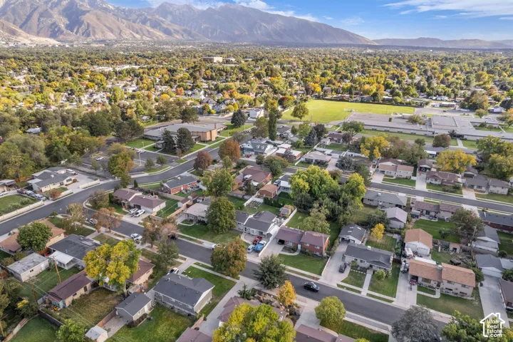 Residential neighborhood with established streets and mature trees, featuring a distant mountain range