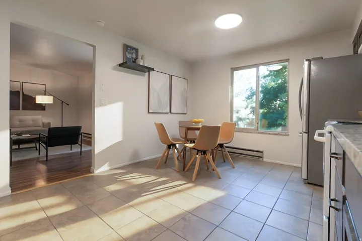 Tile flooring, large window, built-in shelving, stainless steel refrigerator, and ample counter space