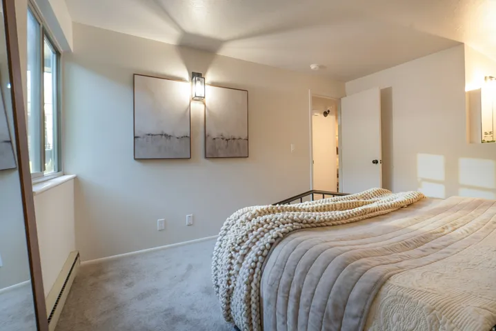 Wall-mounted light fixture, light-colored carpeting, white wall paint, and white trim