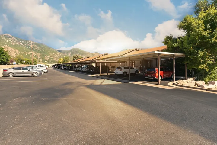Carport parking spaces with paved lot and mountain backdrop