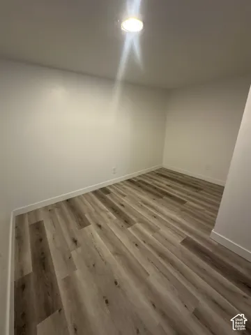 Recessed ceiling light, neutral wall paint, and wood-finish flooring