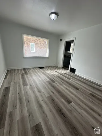 Wood-finish flooring, white walls, and a ceiling-mounted light fixture