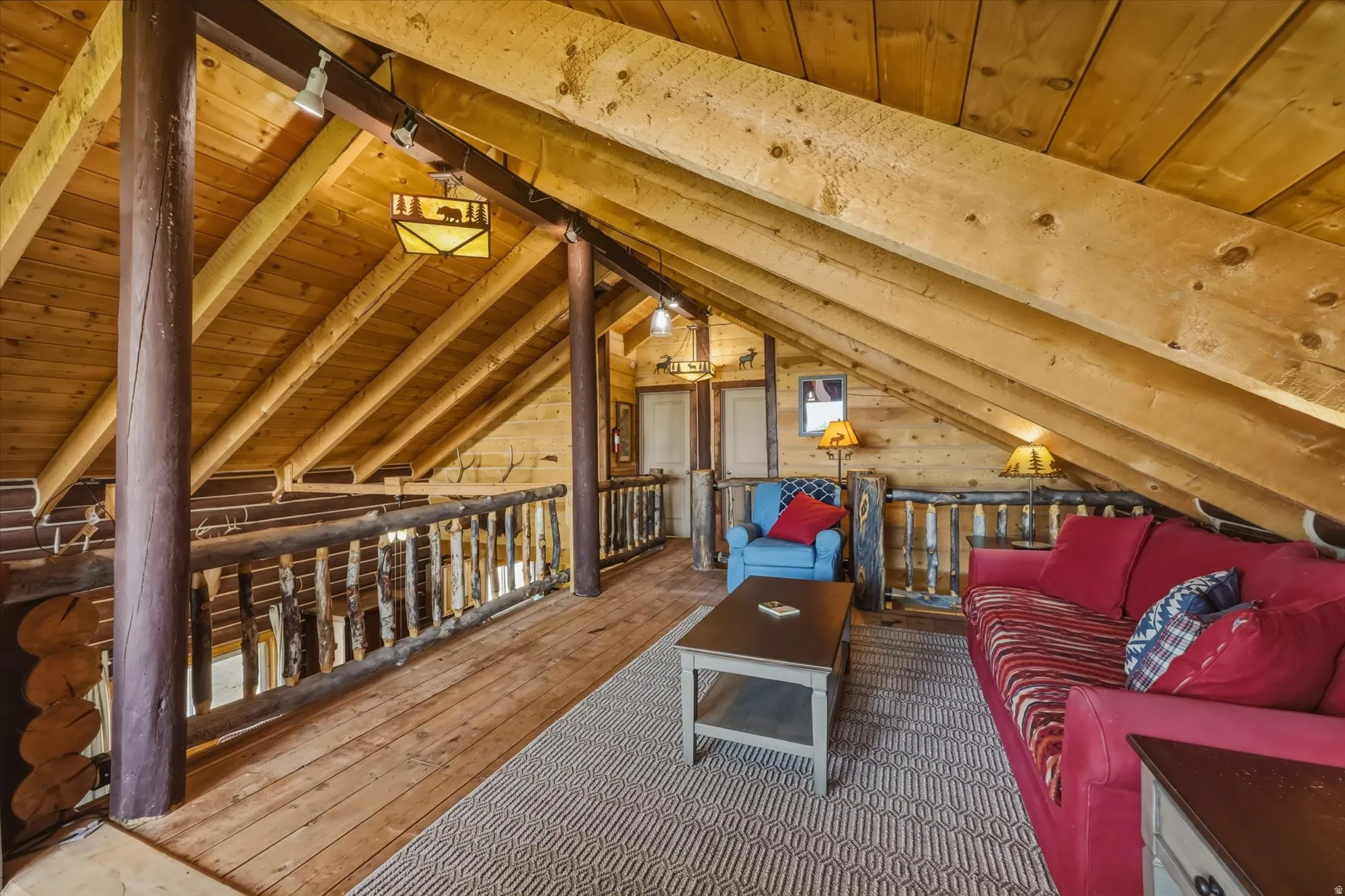 Wood-finish vaulted ceiling with exposed beams, wood-finish flooring, and natural wood railing