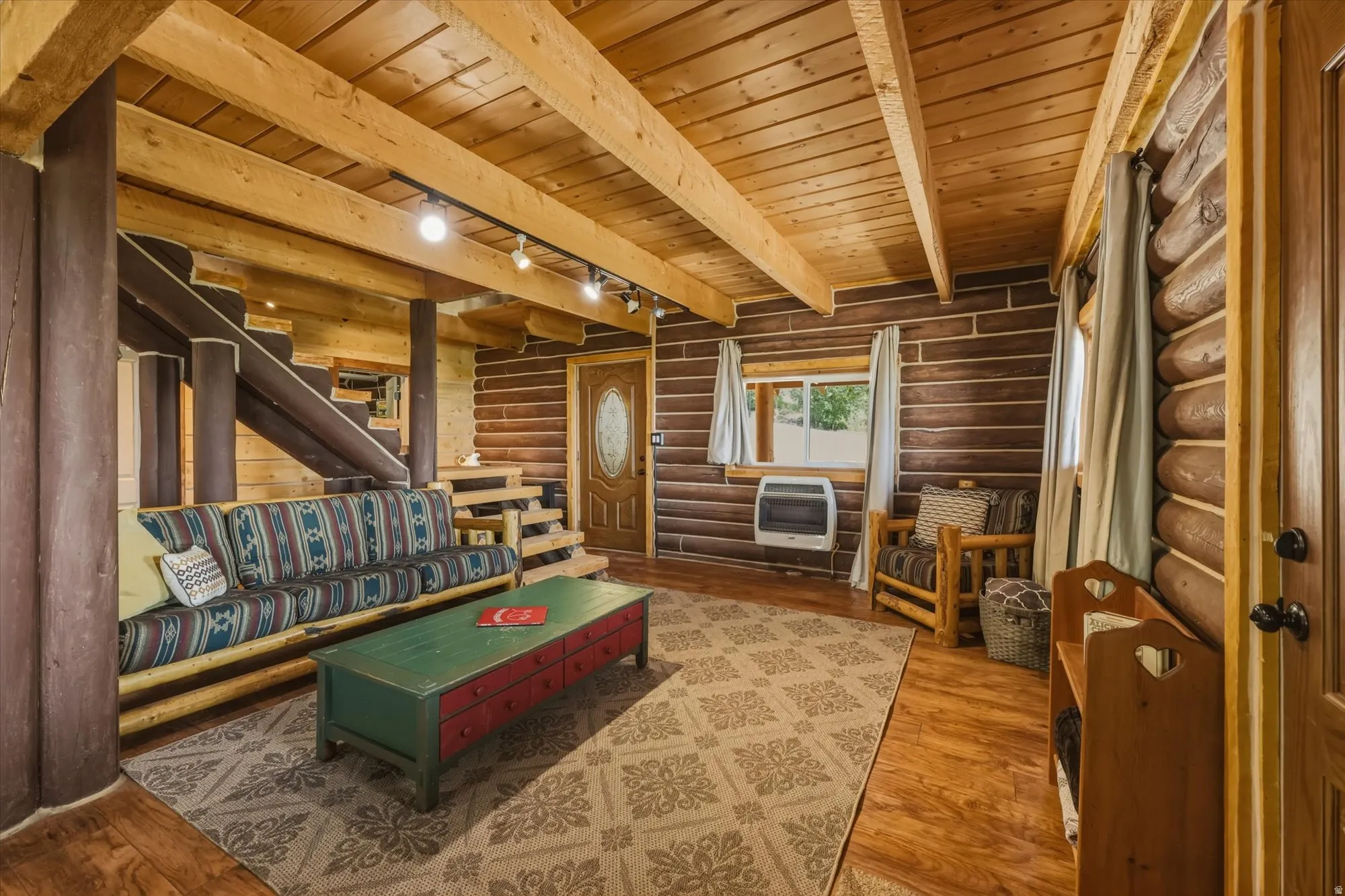 Exposed wood beam ceiling, wood-paneled walls, wood-finish flooring, interior wood door with frosted glass, and a built-in spiral staircase