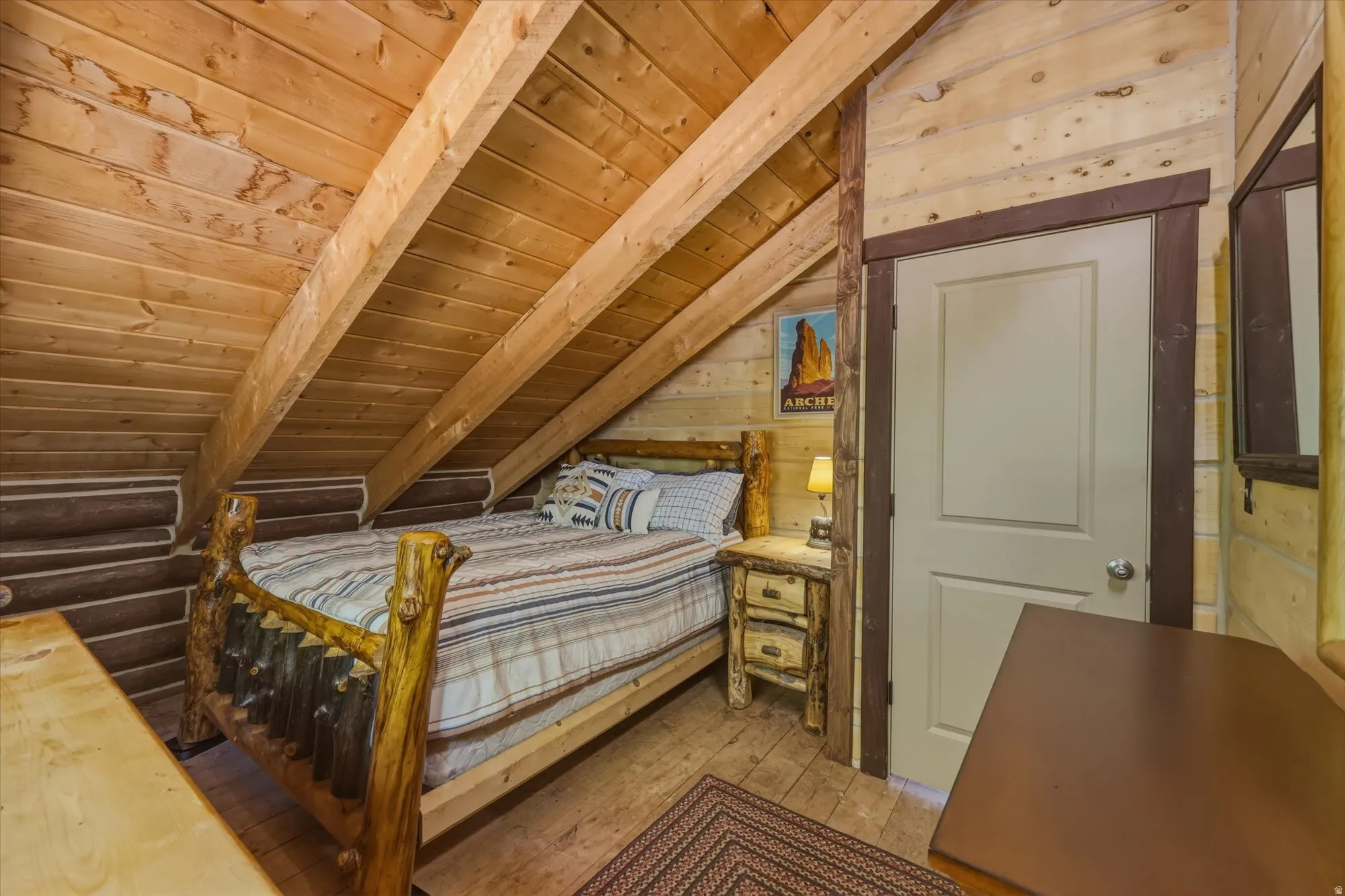 Vaulted wood-paneled ceiling with exposed beams, wood-plank walls, and wood-finish flooring