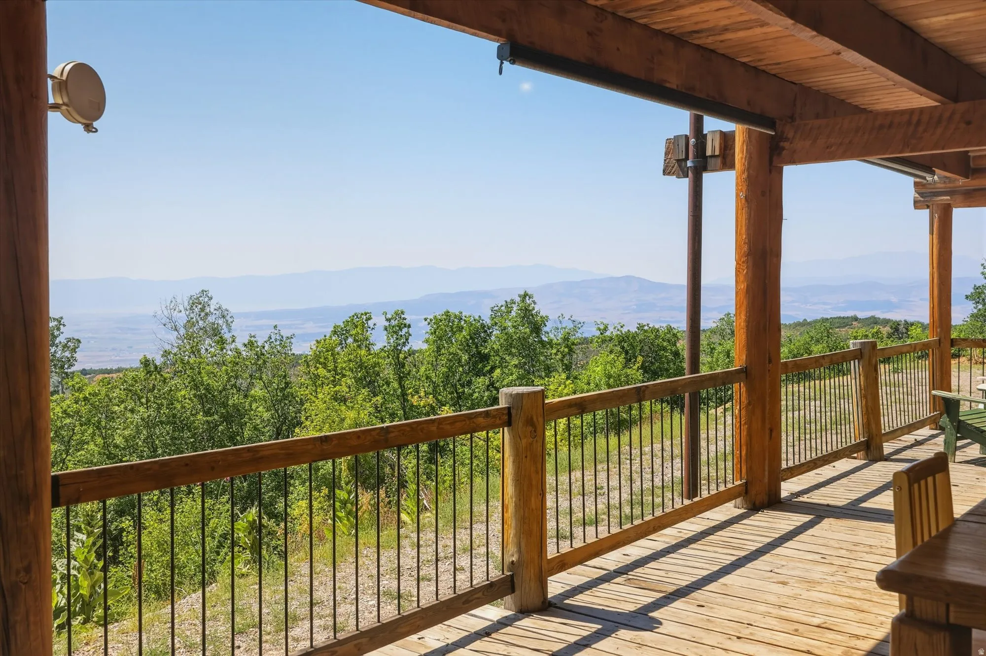 Expansive outdoor deck featuring wood flooring, wood posts, and a wood railing with black metal balusters
