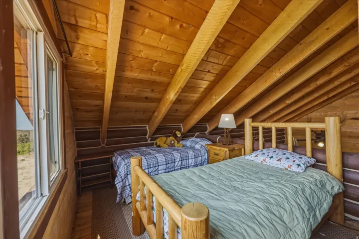 Wood-paneled sloped ceiling with exposed beams