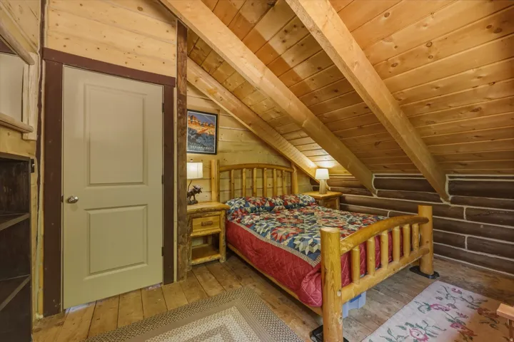 Wood-paneled sloped ceiling with exposed beams