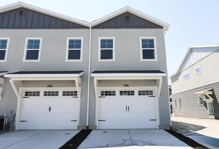 Rear view of corner unit with extra-wide one car garage and driveway permitting additional parking.