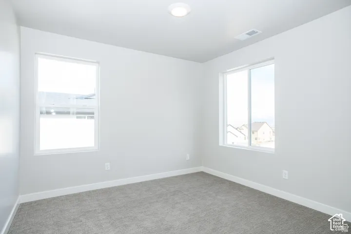 Two windows provide natural illumination, complementing the flush-mount ceiling light