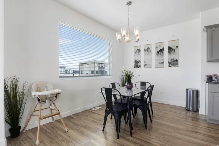Wood-finish flooring, recessed lighting, and a modern chandelier