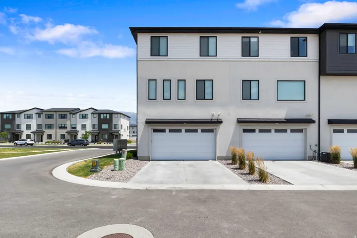 Contemporary multi-story exterior with a two-car garage, concrete driveway, and minimalist landscaping