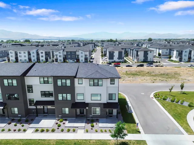 Townhome exterior featuring a modern design, dark grey siding, white stucco accents, and multiple windows