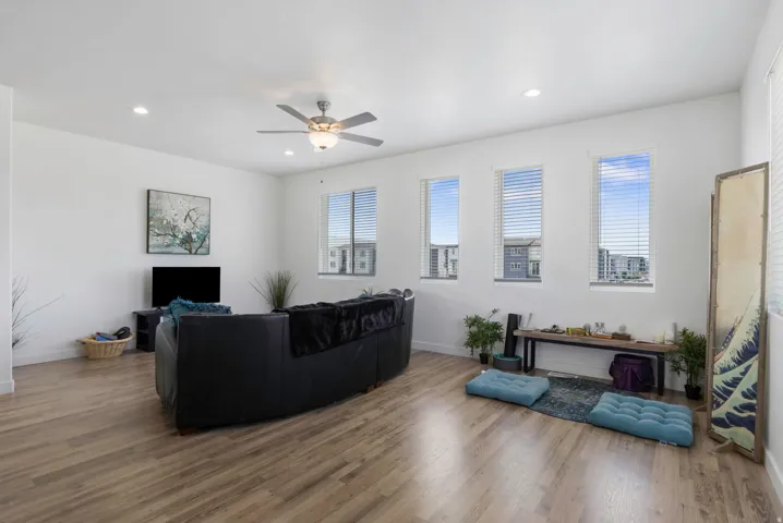 Wood-finish flooring, recessed lighting, and a ceiling fan with integrated lighting