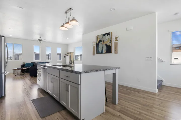 Kitchen island with a granite countertop, undermount sink, and stainless steel faucet