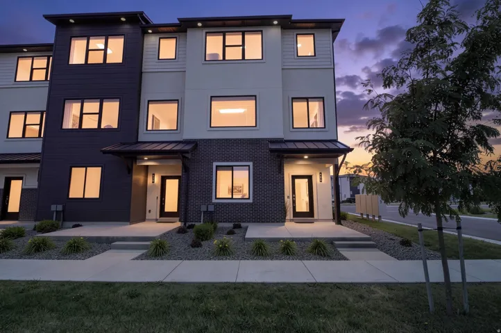 Contemporary townhome with a multi-textured facade including siding and brick accents