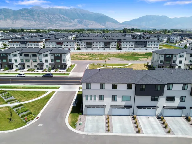 Contemporary townhome community with attached garages, paved driveways, and mountain backdrop