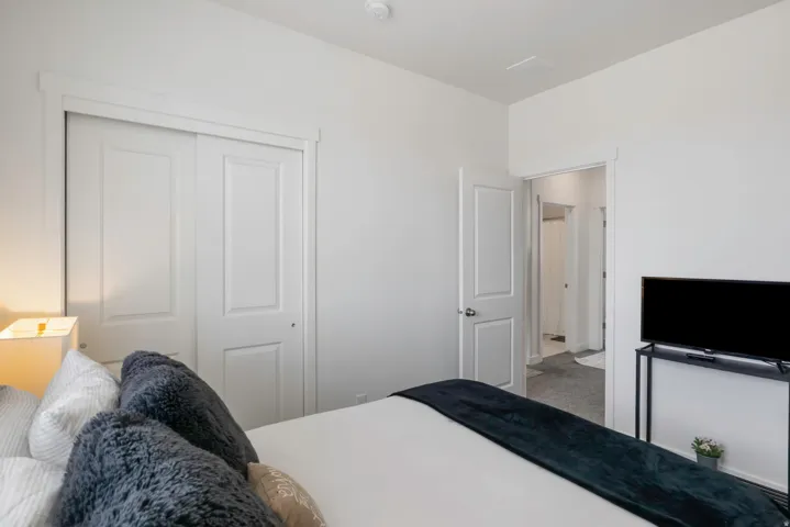 White walls with white trim, a white paneled sliding closet door, and a white paneled interior door with silver hardware