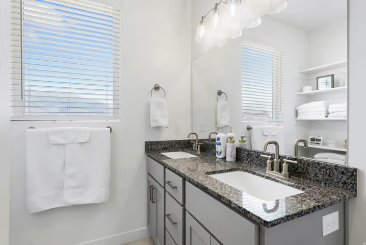 Dual vanity with undermount sinks, stone countertops, and brushed nickel fixtures