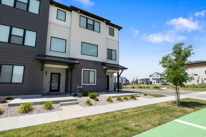Modern townhome exterior featuring multi-toned siding and brick accents