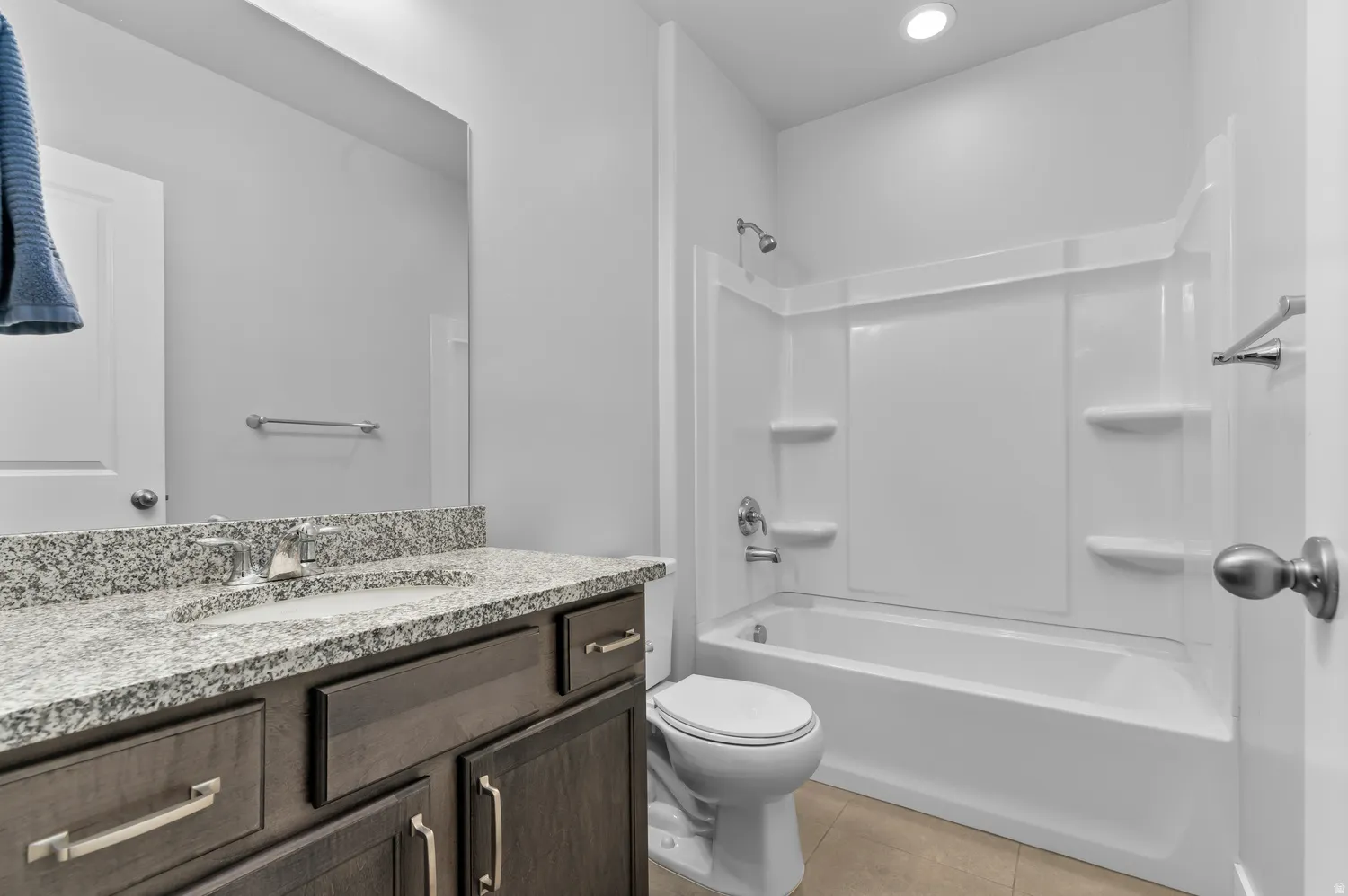 Vanity with a granite countertop, integrated sink, and wood-finish cabinetry