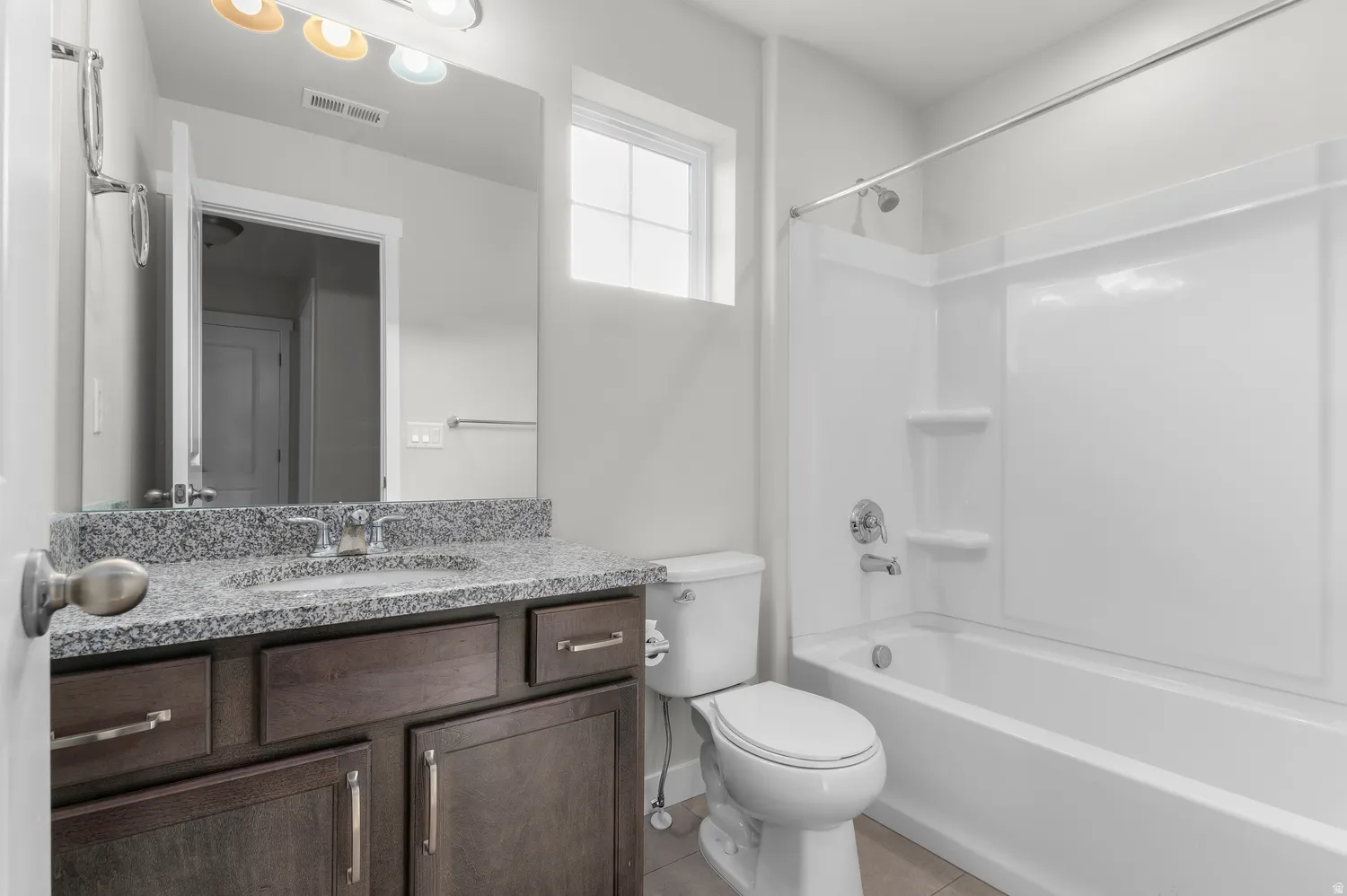 Bathroom featuring a vanity with a stone countertop, an integrated sink, and dark wood-finish cabinetry