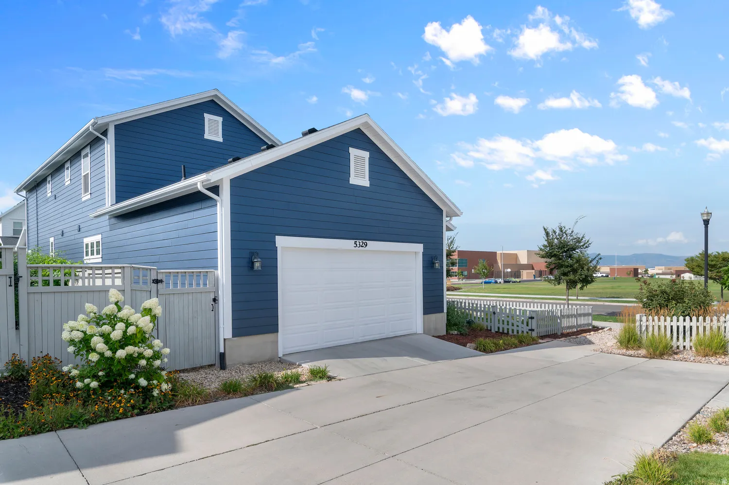 Two-story exterior with horizontal siding, white trim, and a white garage door