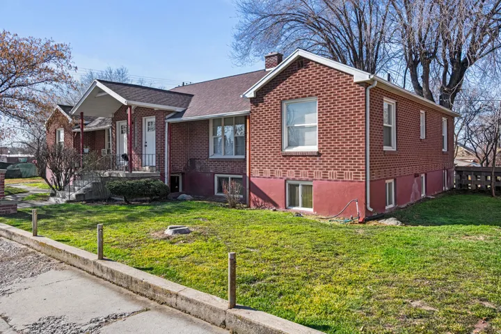 Brick exterior with white trim, multiple windows, and a covered porch entry
